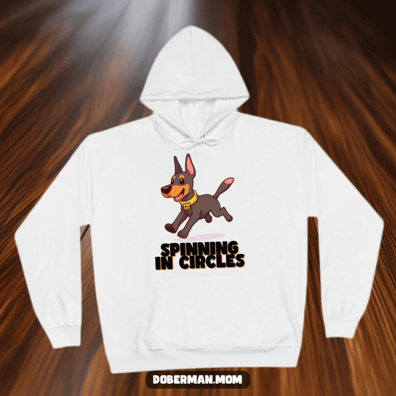 Funny Doberman wearing a tinkling bell collar, playfully chasing its tail, featured on a warm hoodie.