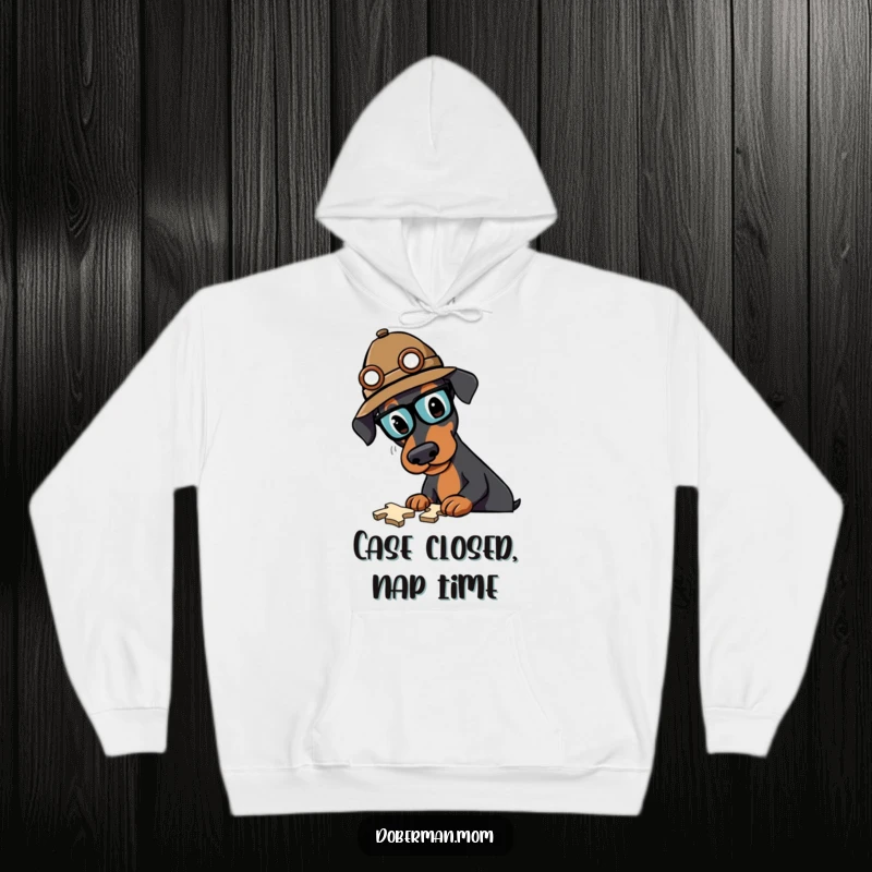Funny Doberman detective hoodie showing a serious dog in a hat, intensely focused on solving a mind-boggling puzzle.