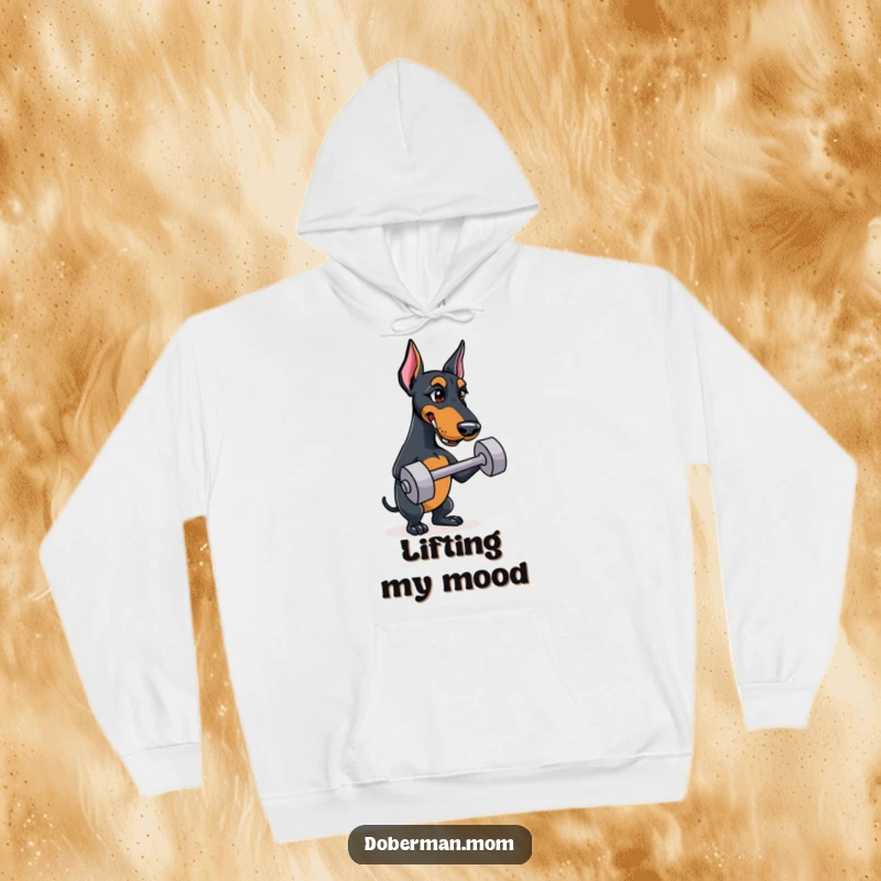Funny Doberman hoodie featuring a determined dog focused on balancing a small training dumbbell, ideal for fitness buffs.
