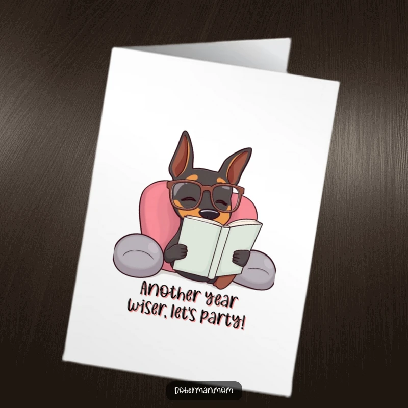 Funny Free Printable Doberman wearing reading glasses relaxing with a book for a birthday card.