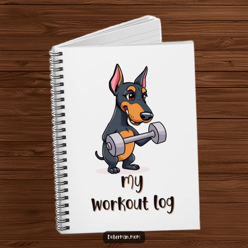 Funny Doberman notebook with a determined dog balancing a small training dumbbell on its cover, perfect for notes.