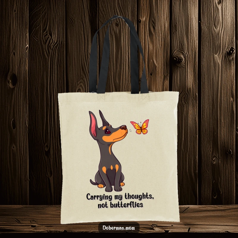 Funny Doberman tote bag, a dog tilting its head curiously to watch a butterfly flutter nearby.