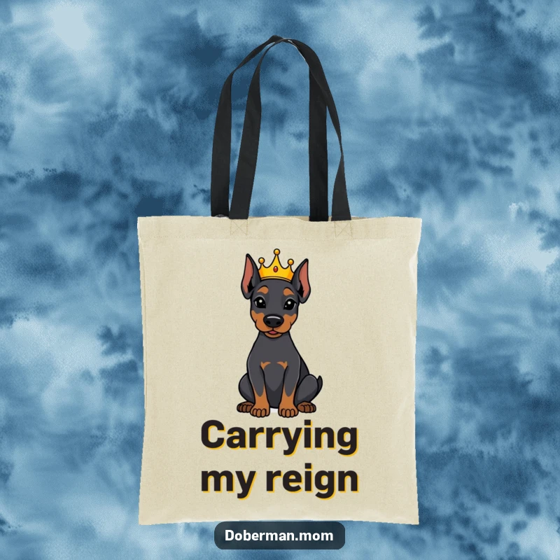 Funny Doberman dog with a tiny crown, sitting attentively on a stylish tote bag, a humorous accessory for royal dog fans.